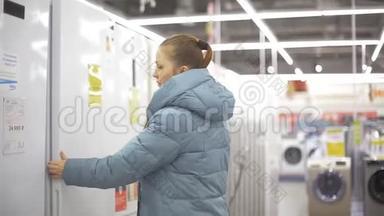 女人在<strong>电子超市</strong>选择厨房电器。